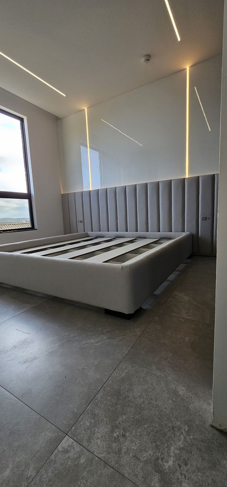 Cama estofada sob medida com cabeceira estofada e iluminação em LED